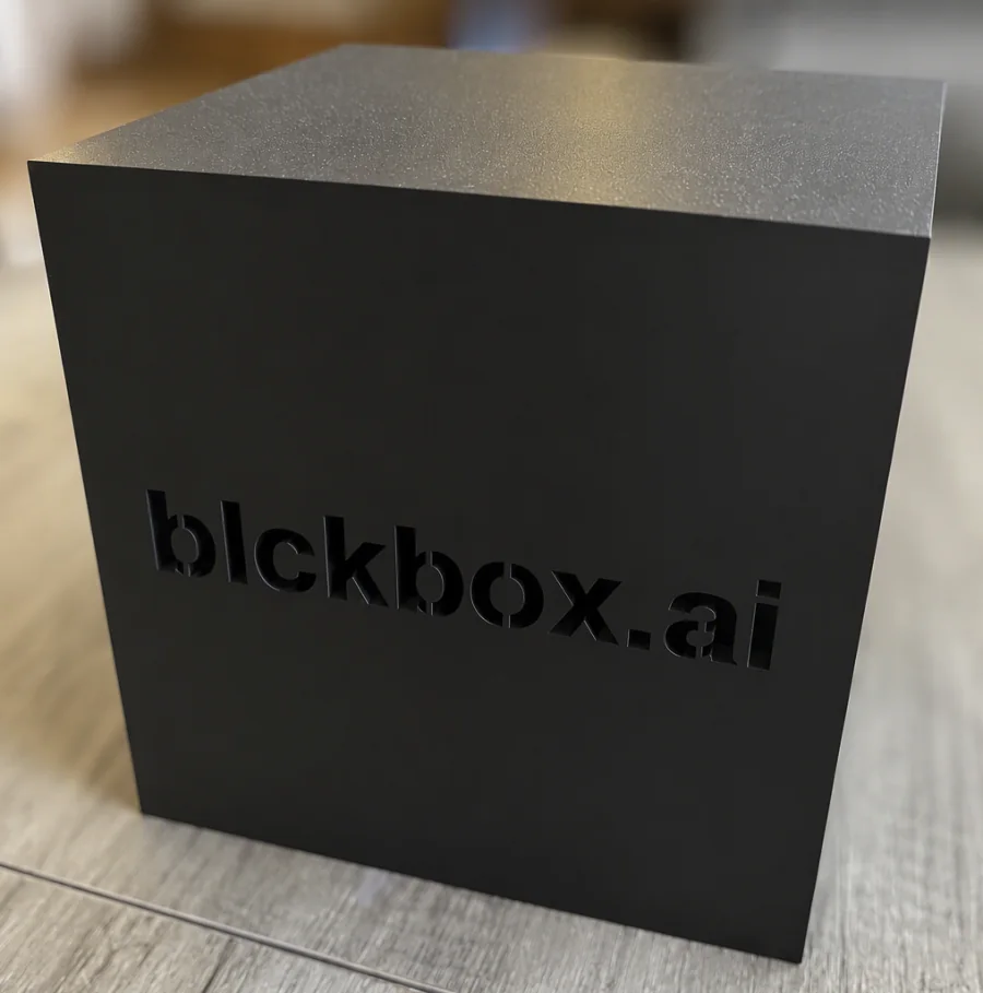 Black custom-made blckbox.ai cube with a silver top